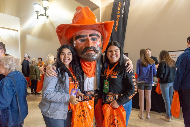 Pistol Pete poses for picture with two students
