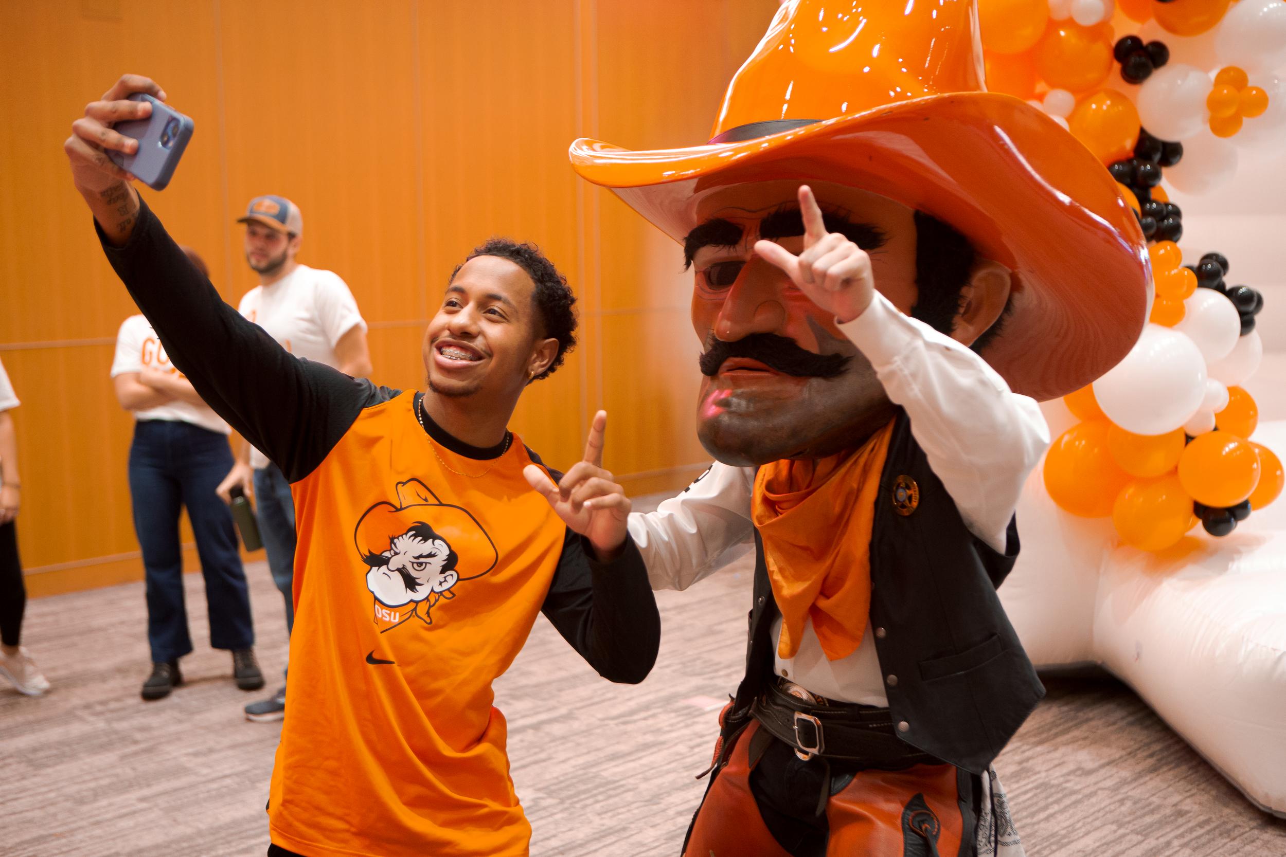 Pistol Pete taking a selfie with an the OSU Homecoming King