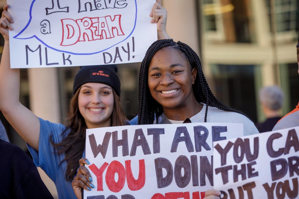 A young woman holds up a poster for a Martin Luther King Jr. march