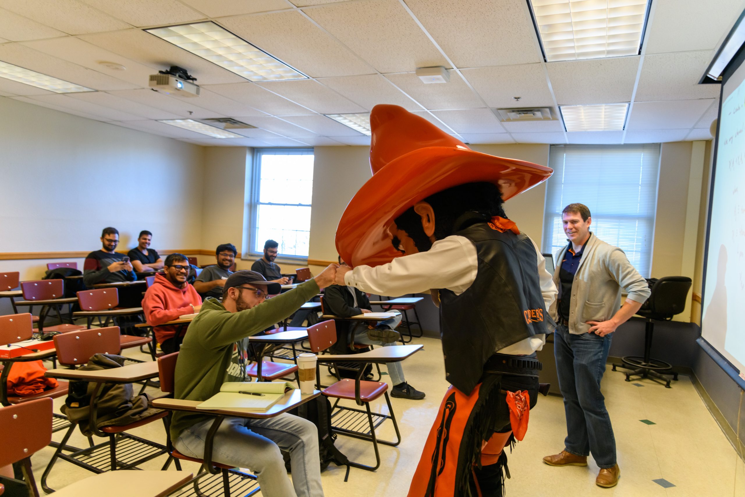 Pistol Pete fist bumping a student in the classroom