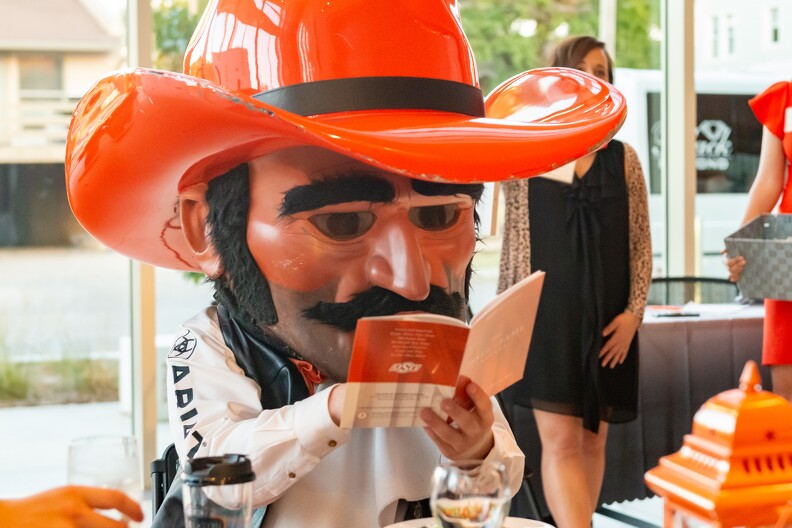 Pistol Pete is holding up a book he is sifting through to find information.