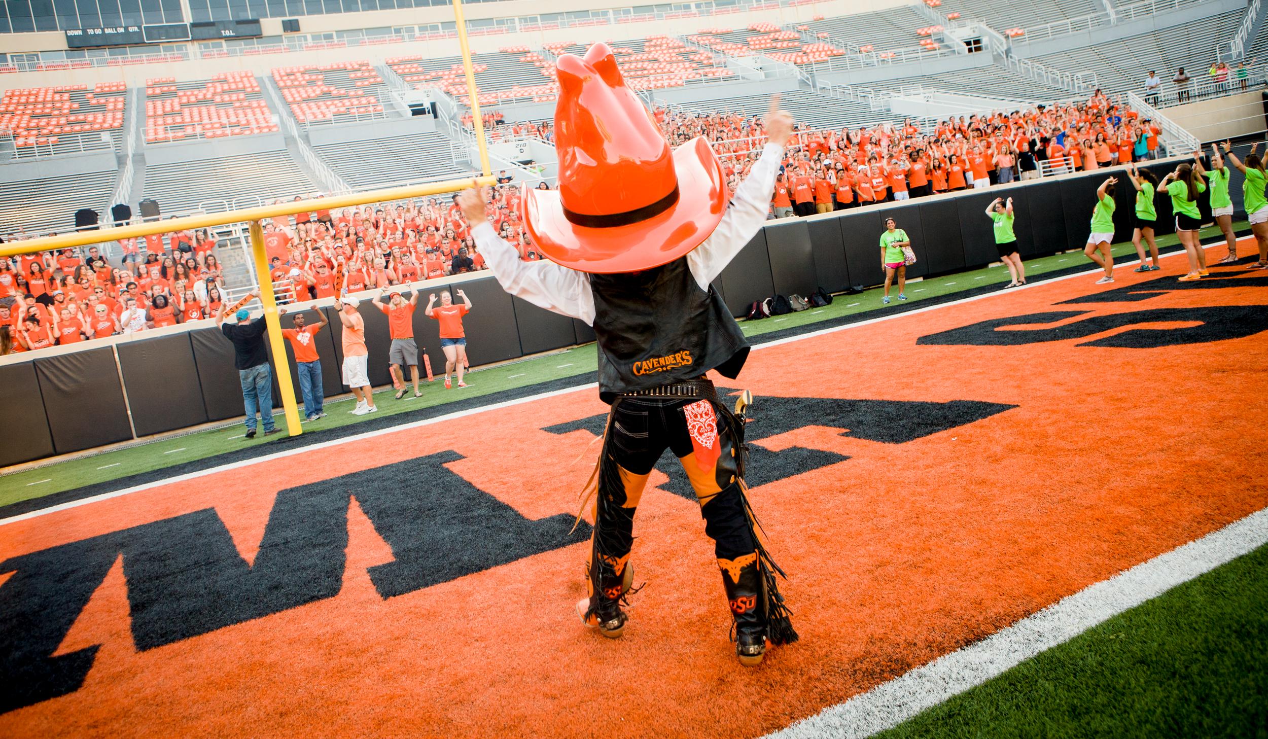 Pistol Pete interacting with an OSU crowd in the football stadium.