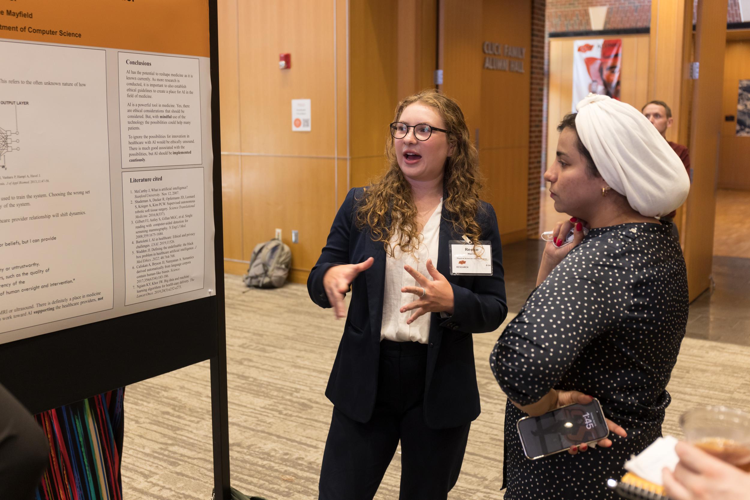 A young female describes her research to another person.
