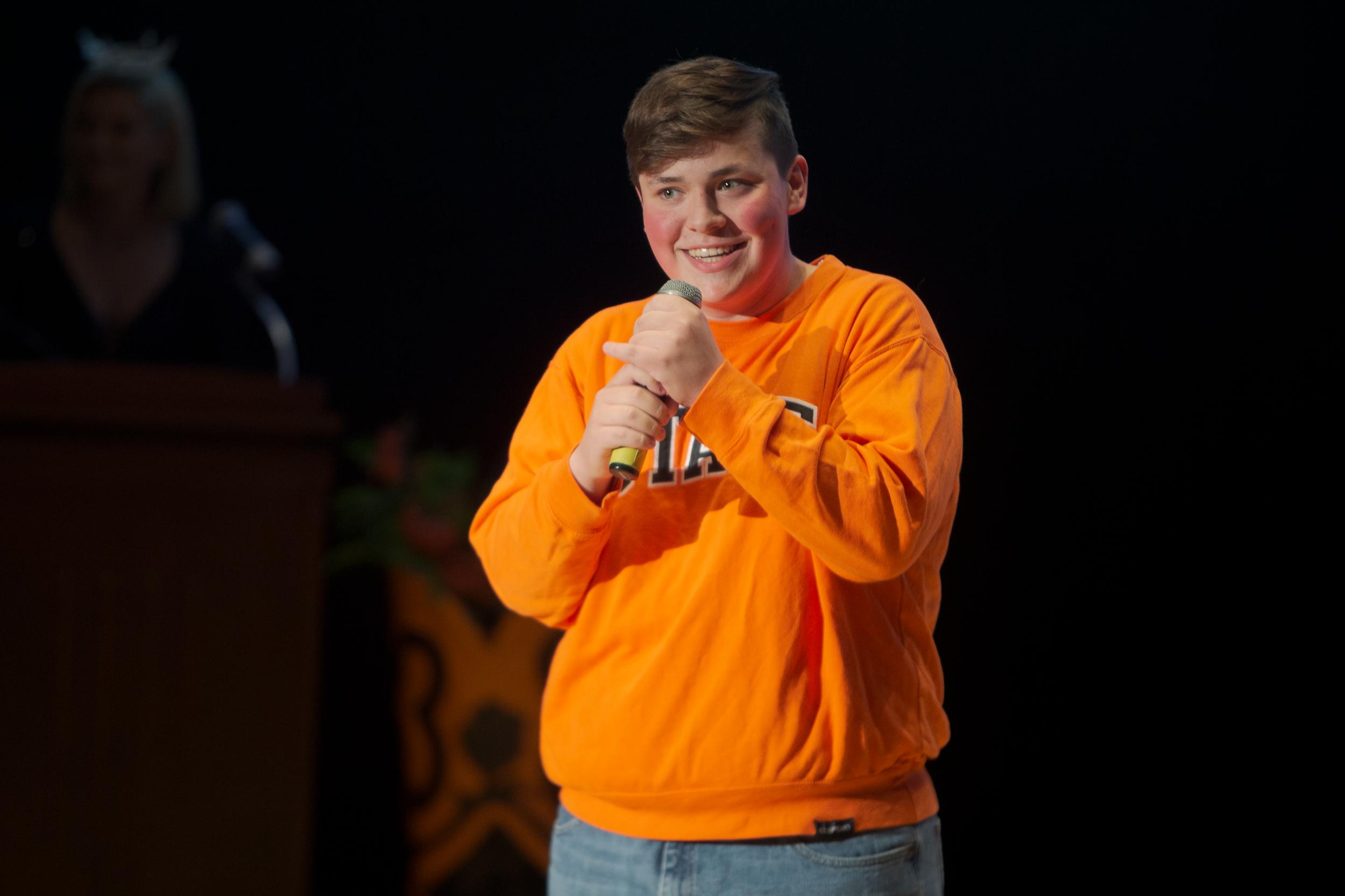A young man wearing an OSU sweatshirt speaks into a microphone
