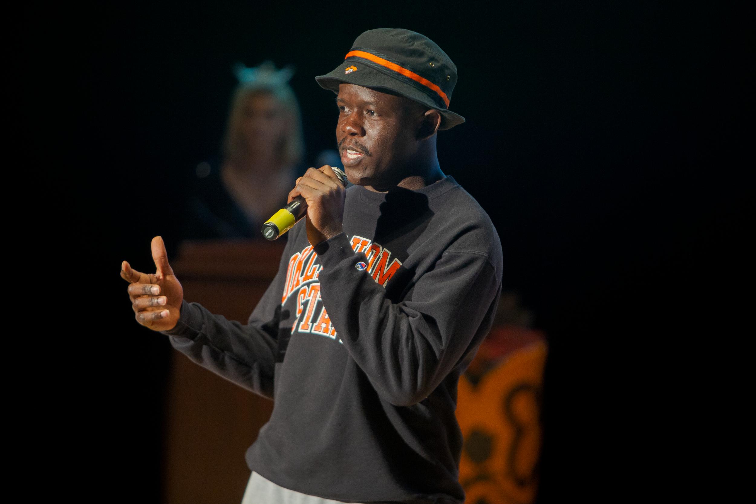 A young black man speaks into a microphone at the Mr. OSU contest