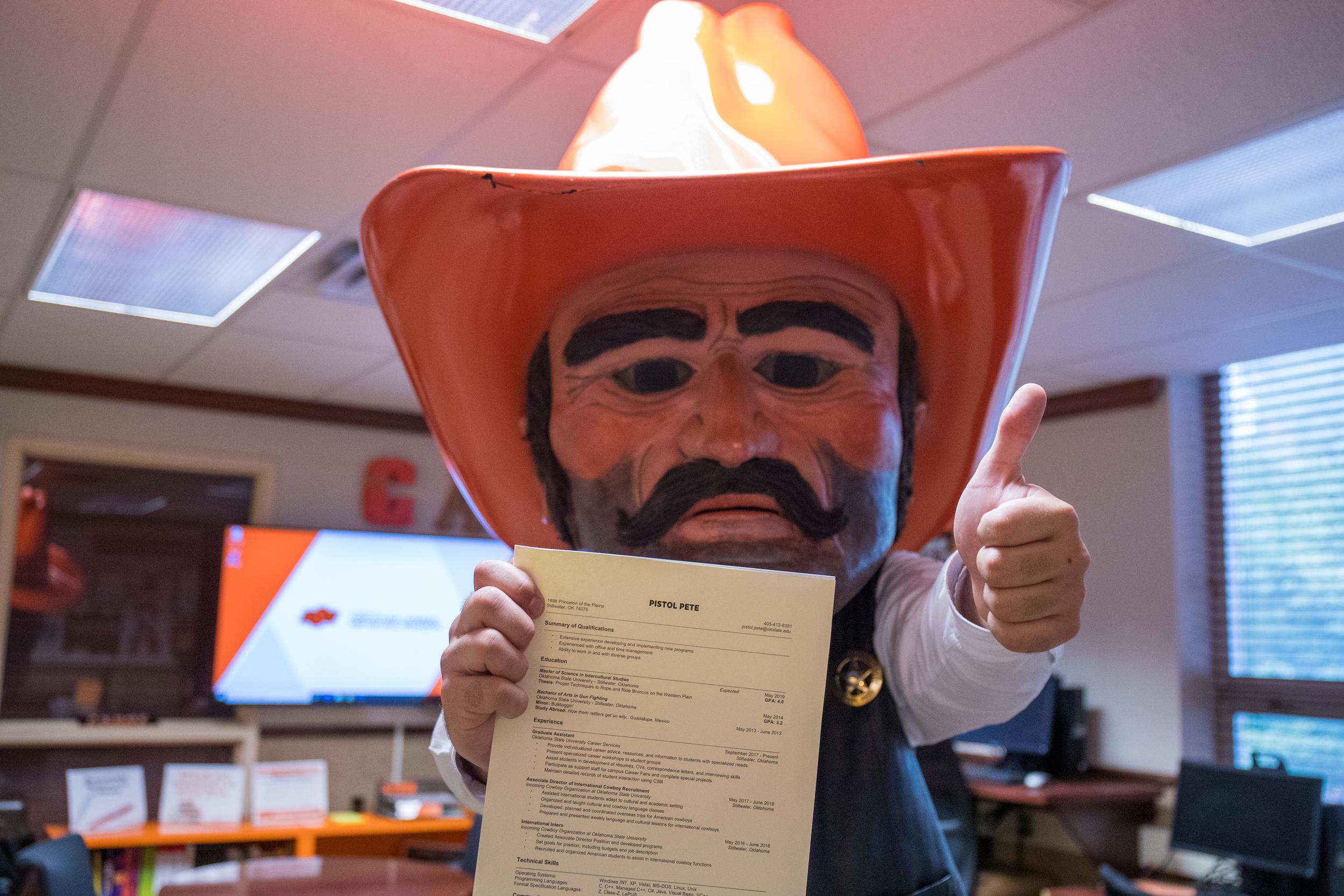 Pistol Pete holds a piece of paper and gives the "thumbs up" hand signal.