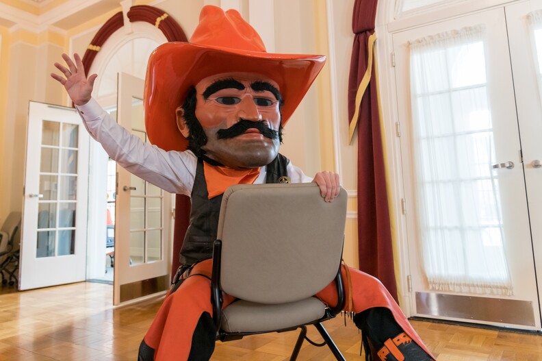 Pistol Pete is playfully sitting in a chair before a speech.