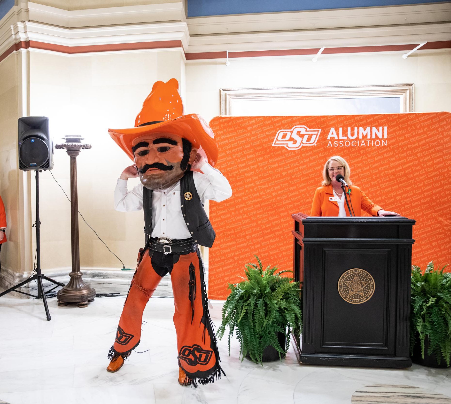 Pistol Pete raises his hands to his ears to encourage energy and noise from his audience.