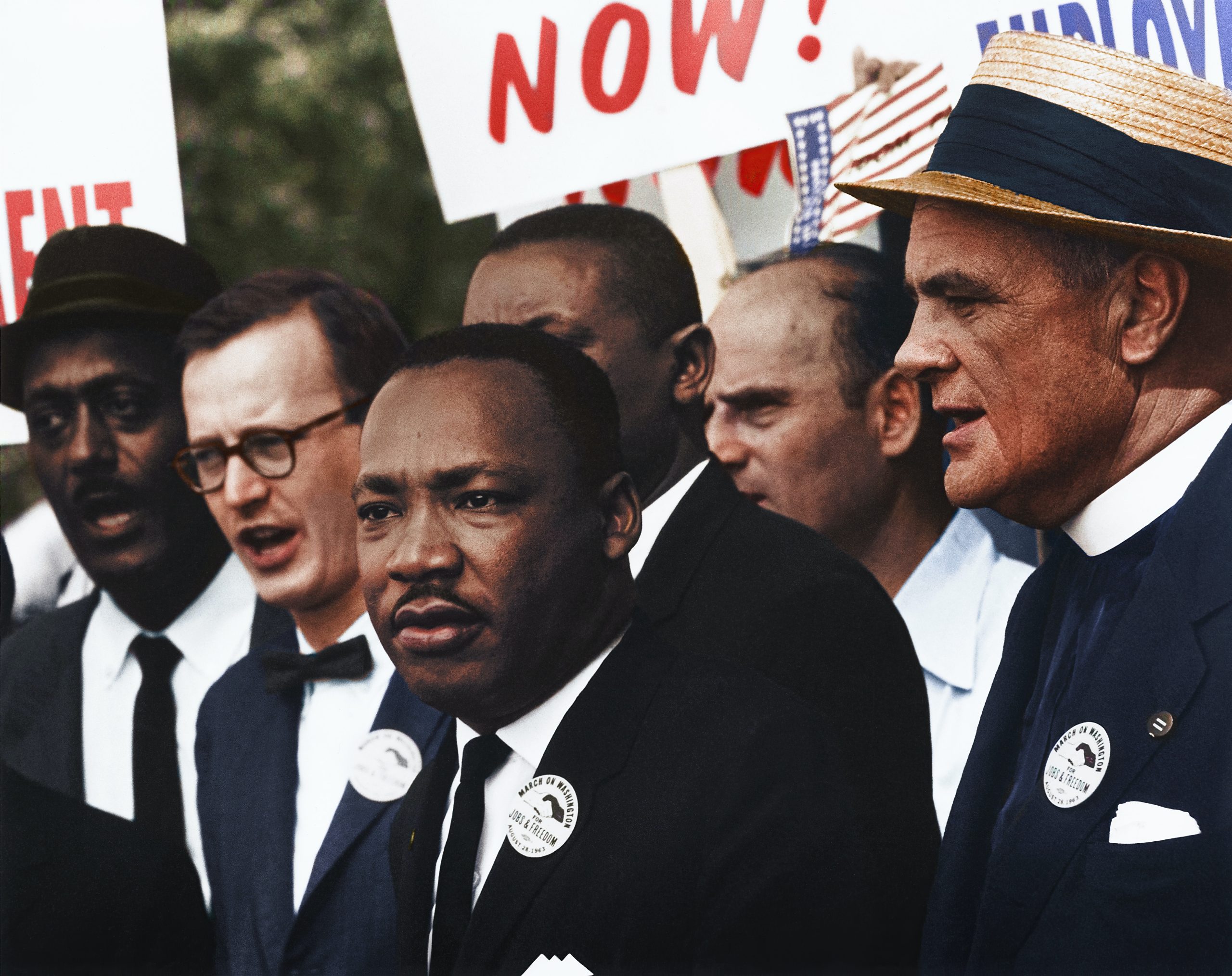 Martin Luther King, Jr. stands with a group of men holding signs in the 1963 March on Washington.