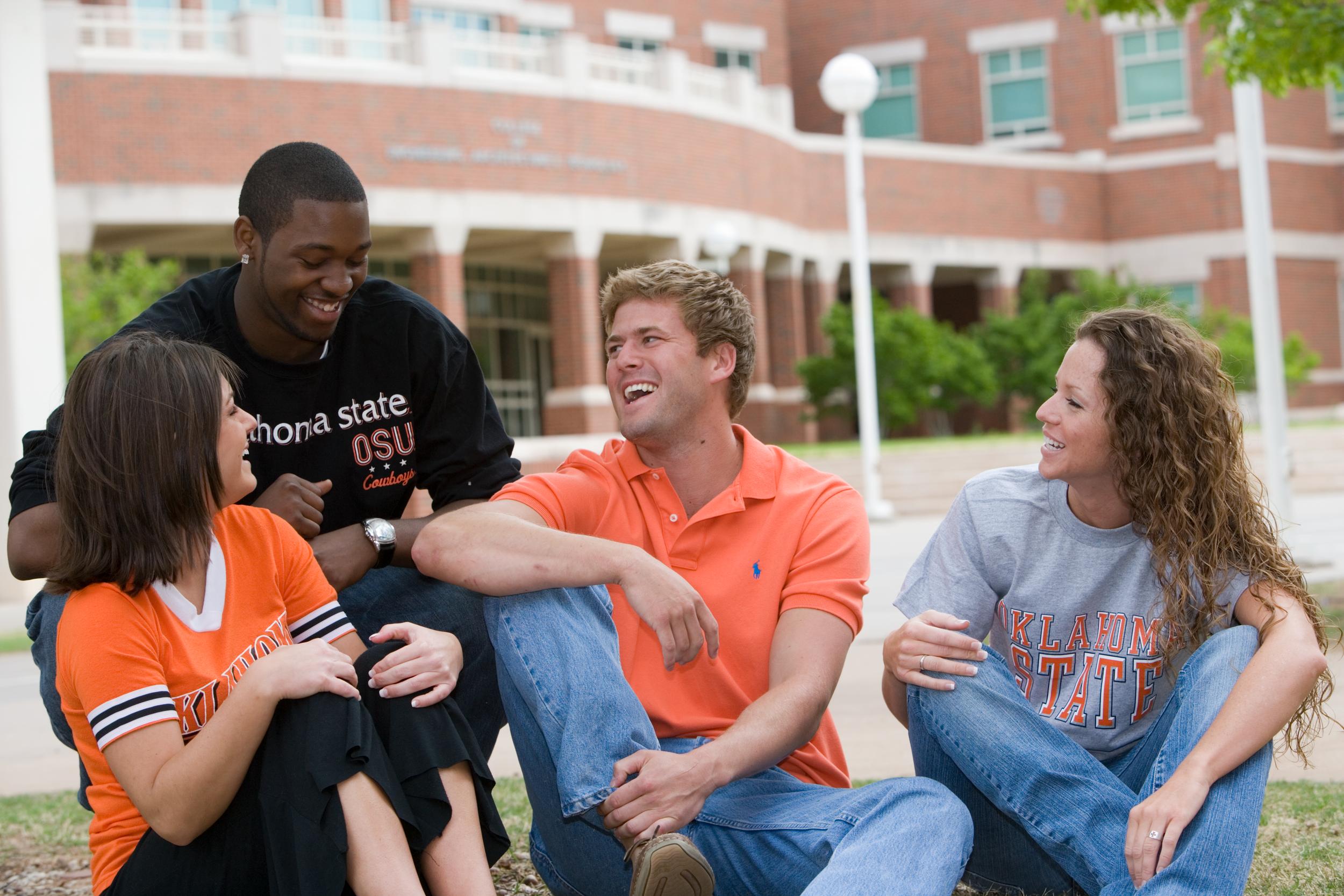 A group of students laughs together in front of OSU's Engineering Building.