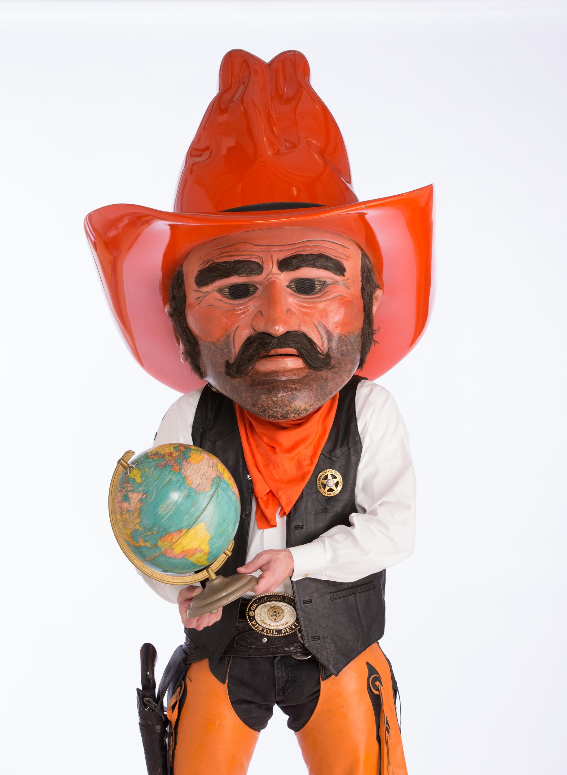 Pistol Pete holds a globe as an aid for his presentation aid for his speech.