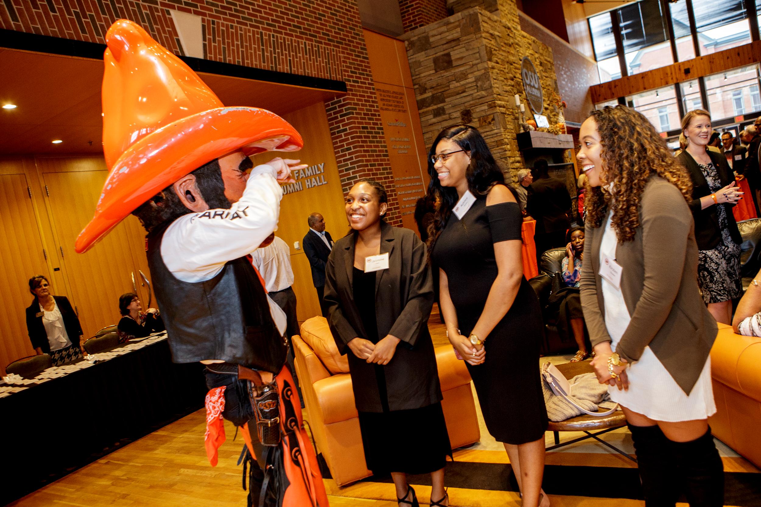 Pistol Pete talk with a group of women at an OSU alumni event.