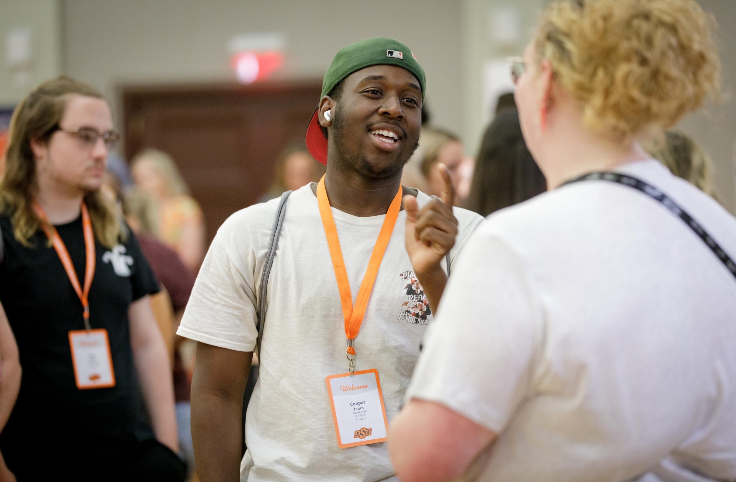 A man smiling and talking to a woman at an OSU event