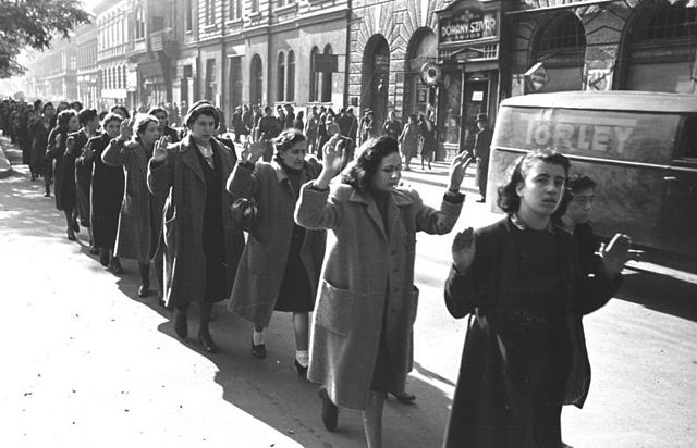 A black and white photograph of Jewish women being arrested in the street, October, 1944.