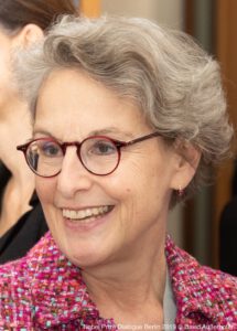 Ursula Staudinger headshot, showing a smiling woman with red glasses and a red blouse.